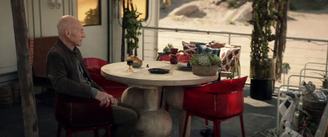 krzesło przy stole, na krześle siedzi jeden z bohaterów Star Treka