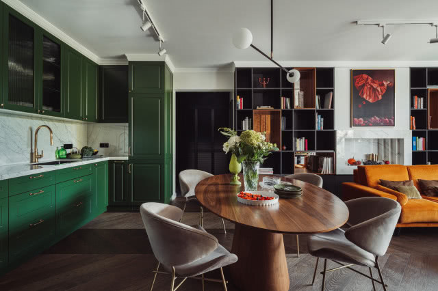 Zielona kuchnia z drewnianym stołem i podłogą