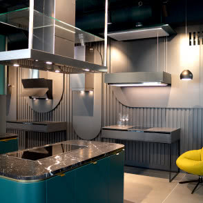 dwie lampy wiszące nad stolikiem kawowym, żółty fotel, pudrowy róż fotel, kuchnia, wyspa kuchenna, okap nad wyspą kuchenną, żaluzje, kanapa