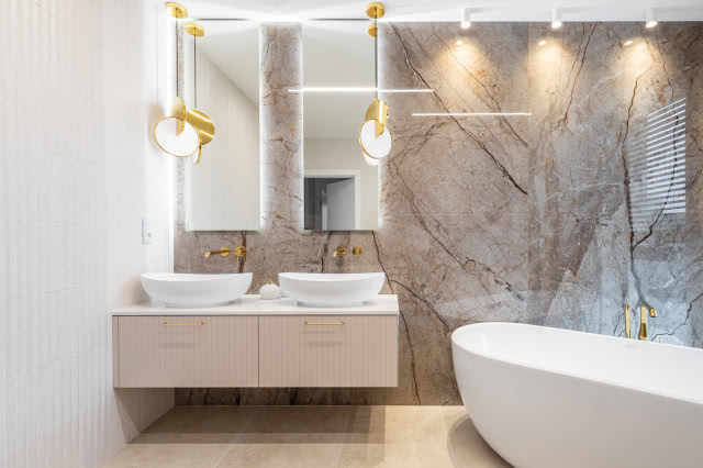 Kamień w łazience ze złotą armaturą