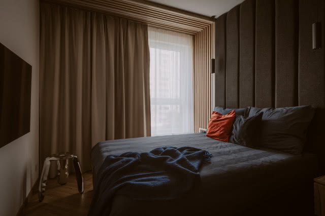 Ciemna sypialnia z panelami tapicerowanymi na ścianie