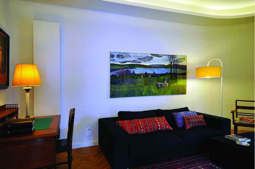 Salon w kamienicy. Za biurkiem widać biały...