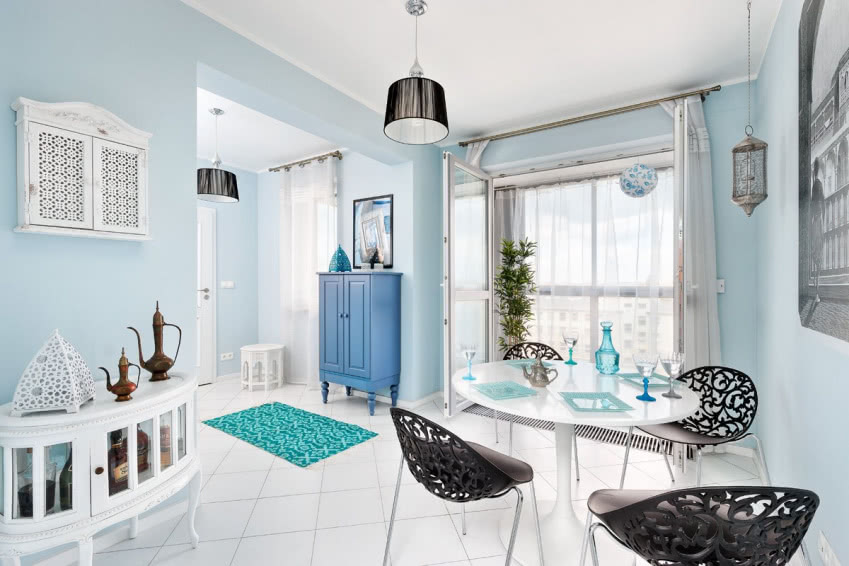 W jadalni stoi biały stół z nowoczesnymi, choć...