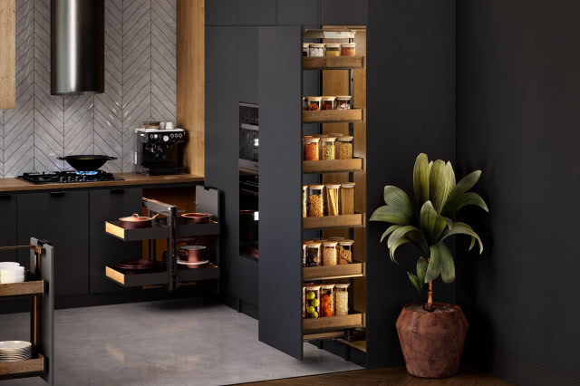 szuflada box, okap, jodełka na ścianie, czarne fronty kuchenne, płyta gazowa, ekspres do kawy, kwiat w doniczce