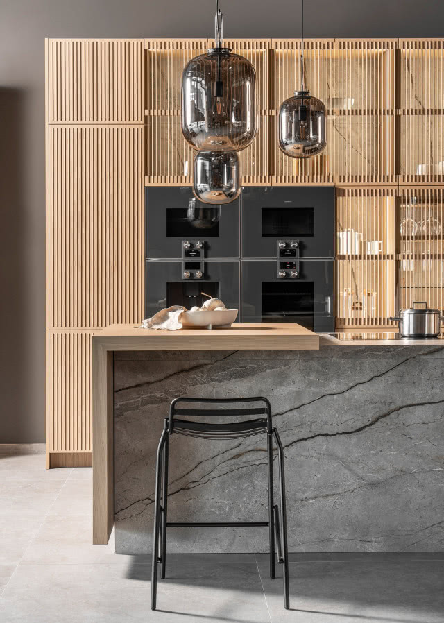 Kuchnia Imperial Oak marki Halupczok w DOMOTECE z drewnianą zabudową, kamienną wyspą i eleganckim oświetleniem.
