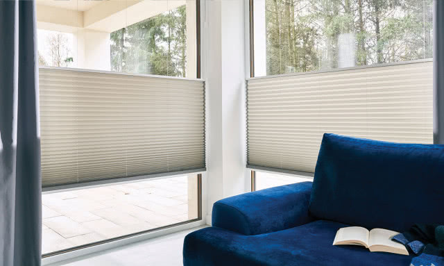 żaluzje, granatowa kanapa duże okna