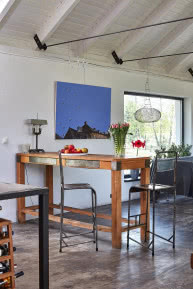 Wysoki stół, drewniany z metalowymi szufladami
i okuciami, ustawiony obok kuchni