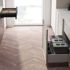 białe meble kuchenne, szuflady, przyprawy, sztućce, jodełka na podłodze, kosze na śmieci, segregacja śmieci, czarna bateria zlewozmywakowa