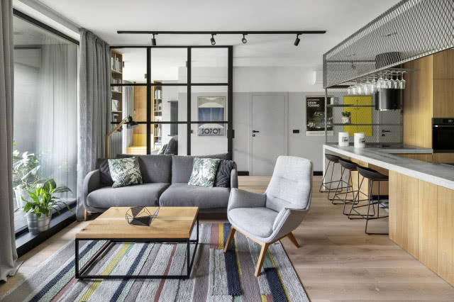 Szklana, industrialna ścianka oddzielająca salon od kuchni