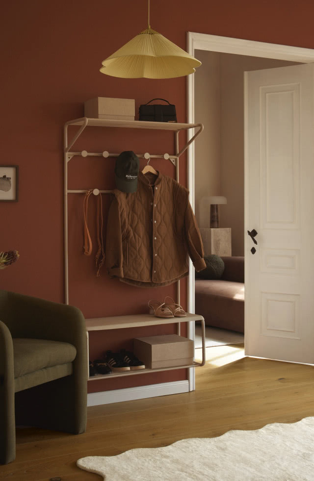 biały metalowy wieszak na tle bordowej ścianie