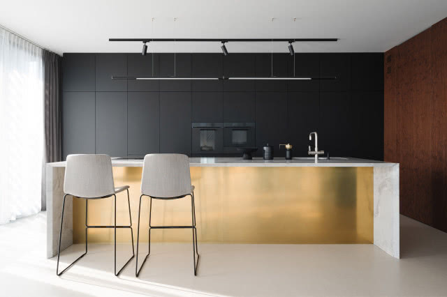 nowoczesna czarna kuchnia ze złotą wyspą kuchenną