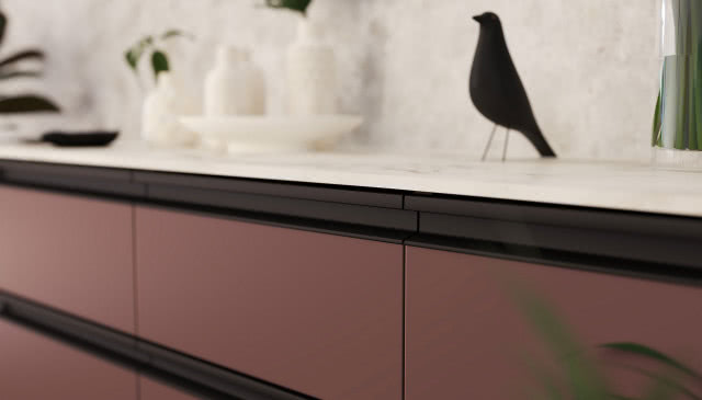 uchwyty Aster, figurka ptaka, biały blat kuchenny, czarne uchwyty