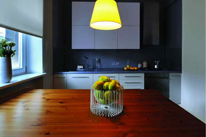 Naturalne drewno ociepla minimalistyczną kuchnię...