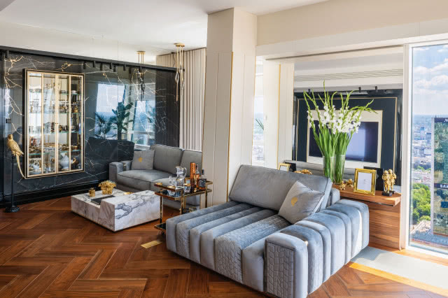 Stolarnia Fryderyka w kooperacji z Barierą Dźwięku przygotowała także ramę telewizora, która biorąc pod uwagę uwarunkowania, jest inżynieryjnym prototypem. Sofy Charisma od Giorgio Collection,  stolik kawowy Bold marki Longhi. Lampy Flos pomógł wybrać  Michał Skodowski z firmy Quest.