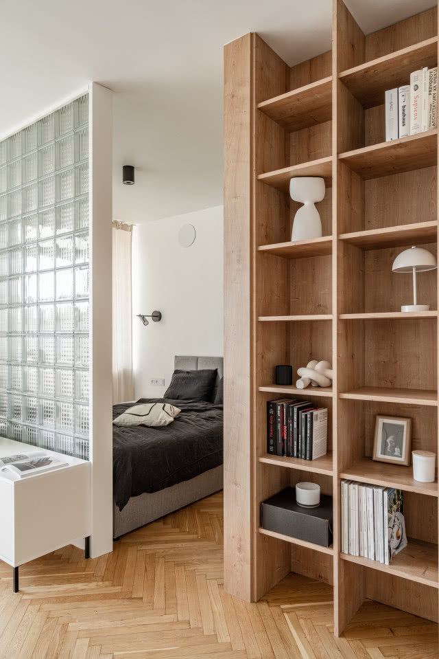 Minimalistyczny salon ze ścianką z luksferów i drewnianą zabudową