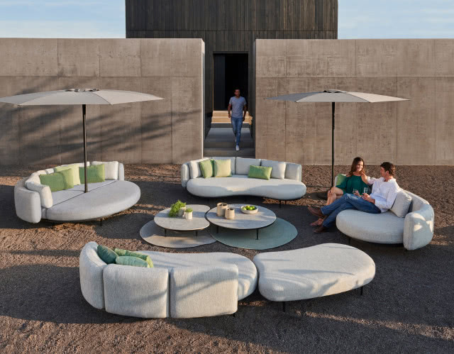 parasole ogrodowe, meble ogrodowe, sofy, kanapy, fotele, poduszki ozdobne, duży dom, mur jako ogrodzenie