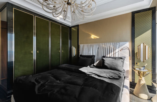 Królewska zieleń na welurowych  frontach szaf oraz dekoracje okienne którymi z pietyzmem zajęła się firma Happy Art z Kamilą i Maciejem Kalskimi  na czele, od razu trafiły w gust  
i serce właściciela. Łóżko Infinity  
od Giorgio Collection.