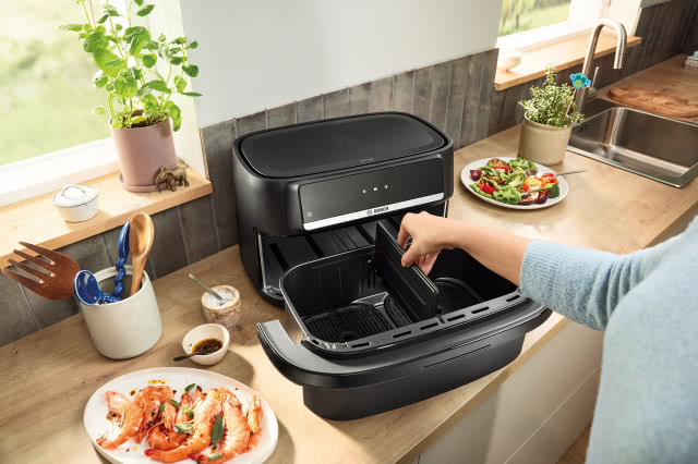 Air Fryer Bosch Serie 4 Double Flex z dwiema strefami gotowania na kuchennym blacie podczas przygotowywania posiłku.