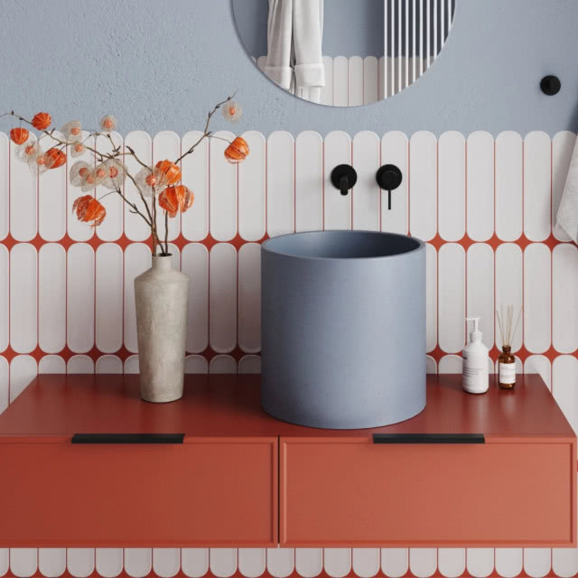 szara umywalka stojąca na pomarańczowej szafce