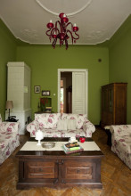 Kanapy w kwiaty i zielone sciany w rustykalnym salonie