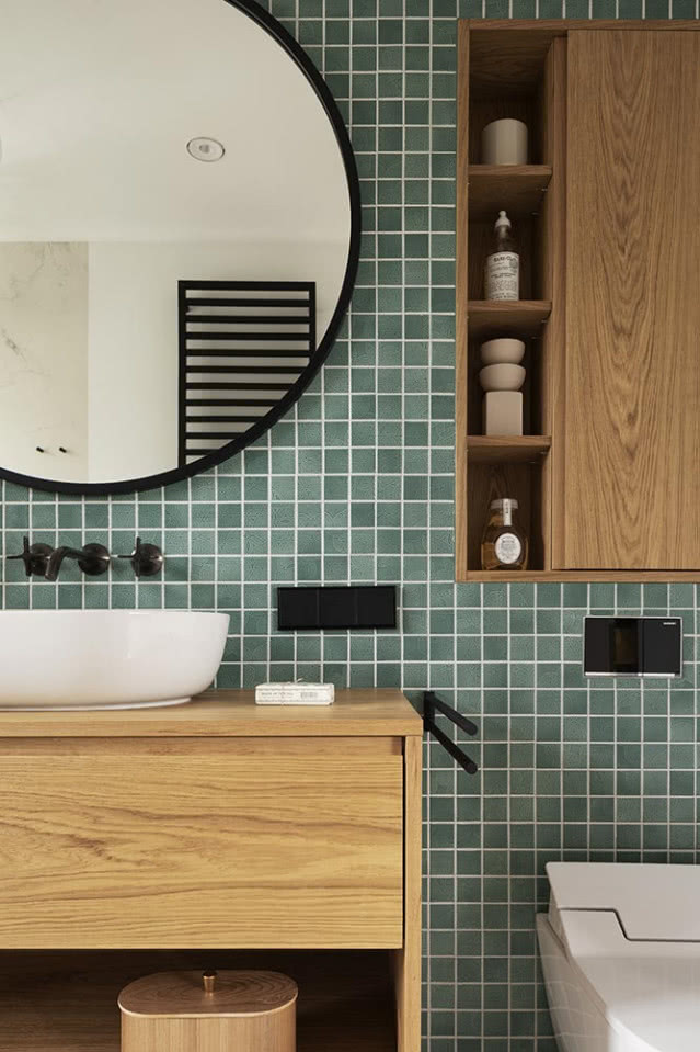 Zielona łazienka ze ścianą z mozaiki i dębowymi meblami