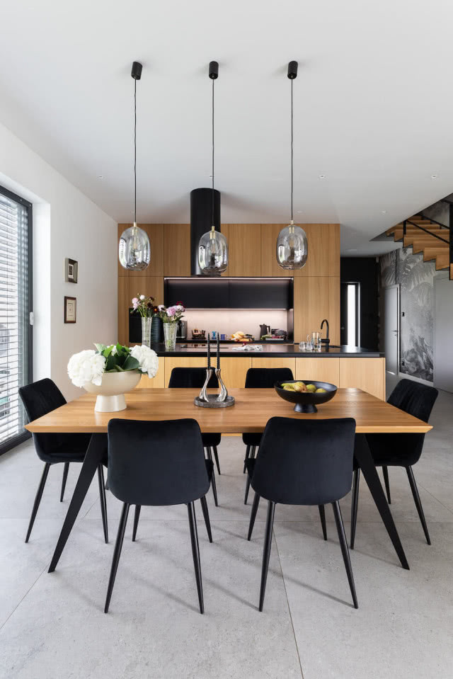 kuchnia w kolorze dębu i czarne krzesła