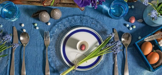 talerz na niebieskiej podkładce ze szczypiorkiem stół na Wielkanoc