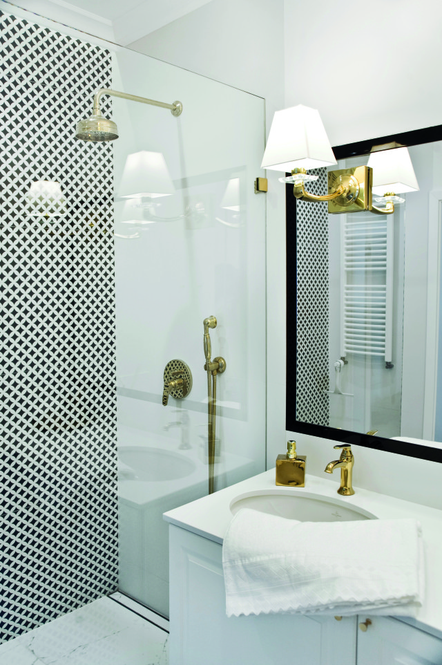 Czarno biała łazienka ze złotymi detalami.