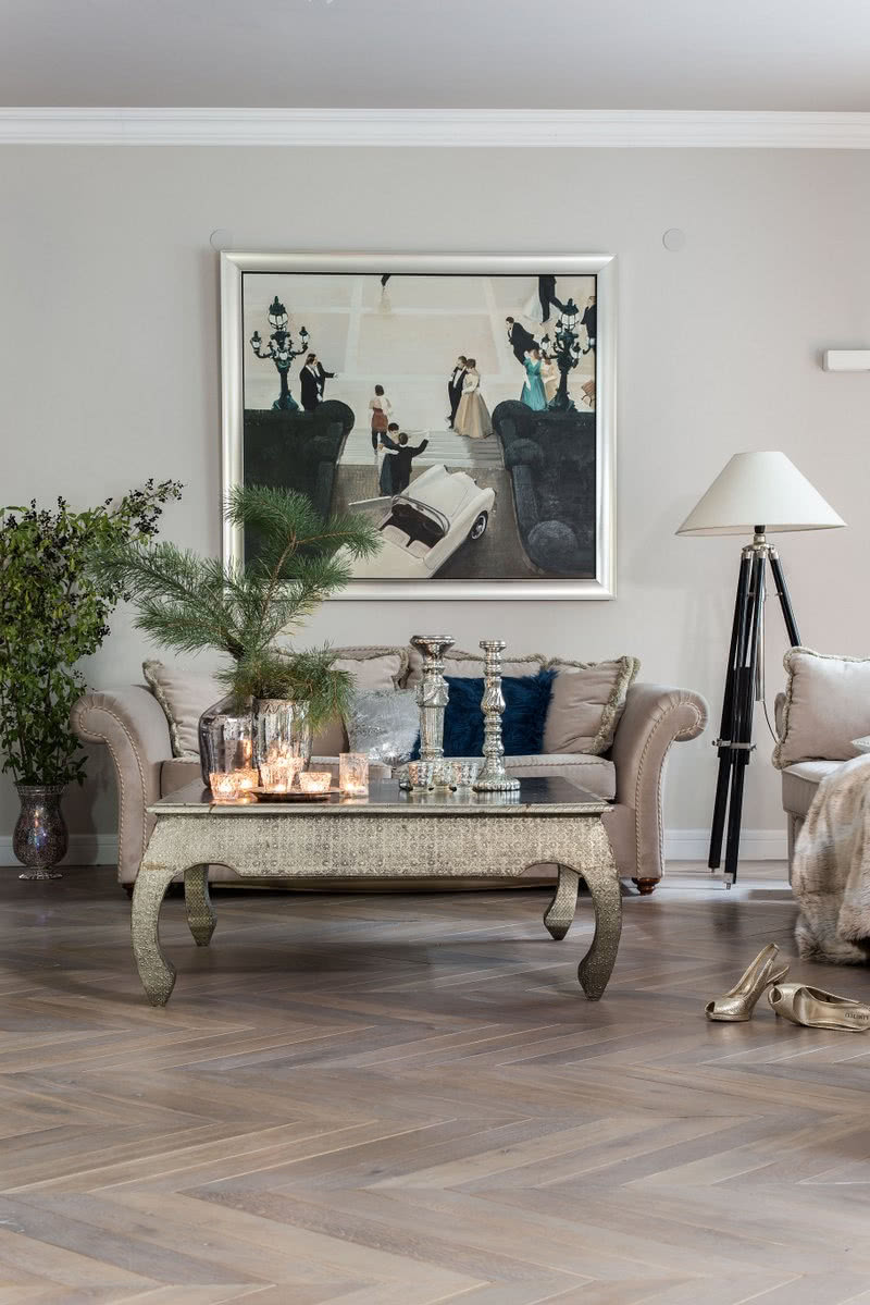 Nad stylizowana kanapa wisi obraz Marka Okrassy...