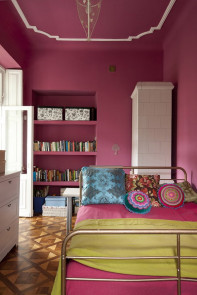 Różowe ściany i białe sztukaterie w rustykalnej sypialni