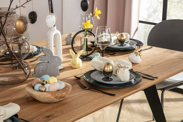 stół Venetti, czarne metalowe nogi, krzesła, jodełka na podłodze, duży kwiat w doniczce, obrazy, oświetlenie sufitowe, szafka z półkami, duże okno