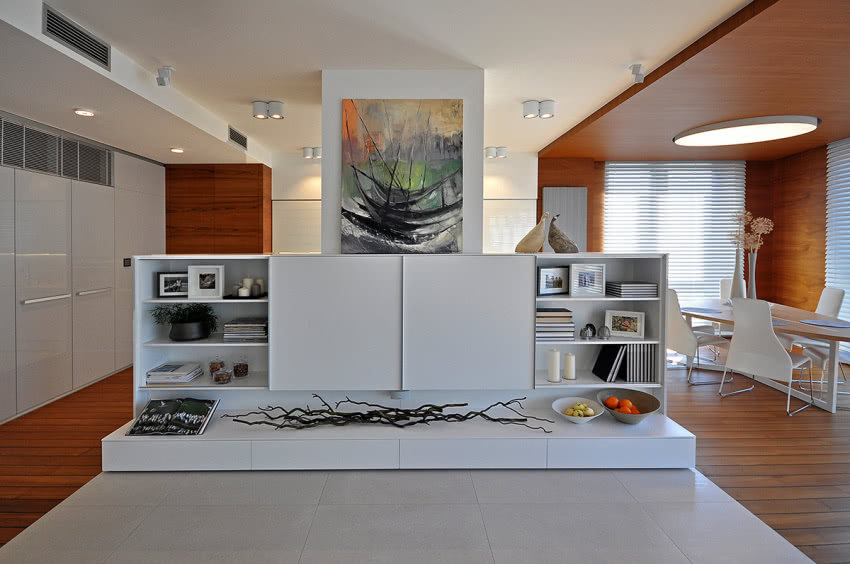 Meblowa ścianka oddziela salon od kuchni, a przy...