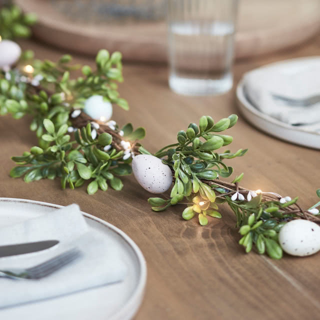 łańcuch z bukszpanowych gałązek jako dekoracja wielkanocnego stołu