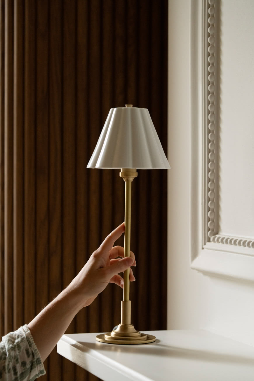 Elegancka lampa stołowa Cotswold z mosiężną podstawą i białym kloszem ustawiona na konsoli w klasycznym wnętrzu.