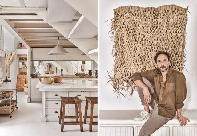 Biała kuchnia w rustykalnym stylu i projektant na tle dekoracji ściennej w stylu boho