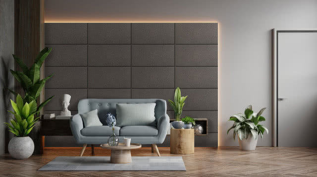 ciemne panele kwarcowe podświetlone, kwiaty, stolik kawowy, szara kanapa, szary dywan, drzwi, belka podpierająca sufit