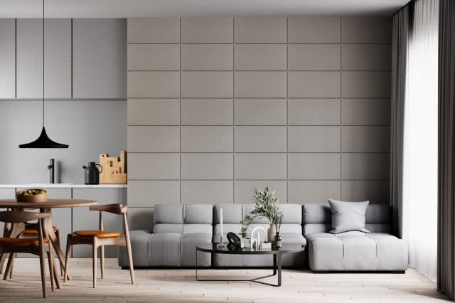 stół z krzesłami, szara kanapa, na ścianie panele kwarcowe w kolorze szarym, stolik kawowy, świece, wazon z zielonymi gałązkami, kuchnia