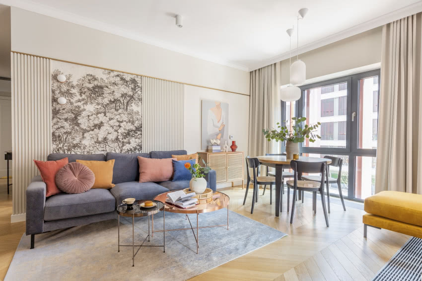 Ścianę za sofą dekoruje imponujący mural Stature...