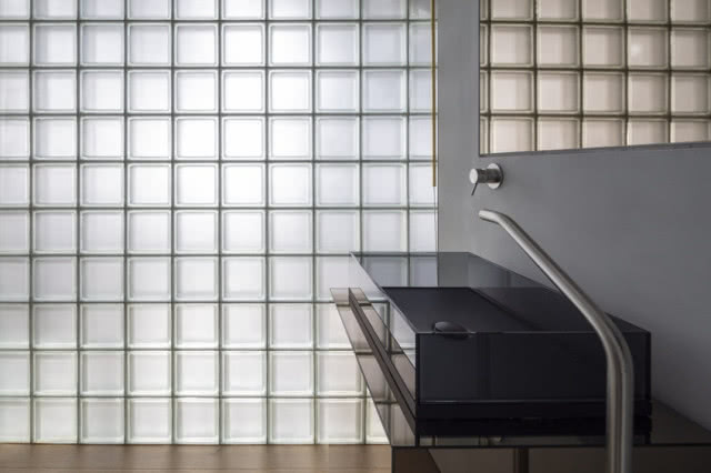 umywalką na tle ściany z luksferów