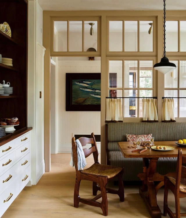 kuchnia, żółta ściana, po lewej szafki kuchenne, po prawej stół