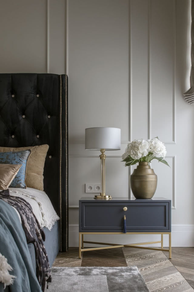 Sypialnia w stylu nowojorskim z granatowym pikowanym łóżkiem