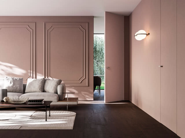 drzwi w kolorze ściany, sztukateria na ścianie, kanapa, stolik kawowy, dywan