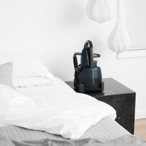 Generator pary Laurastar Lift Xtra Midnight Blue jako designerski element nowoczesnej sypialni zaaranżowanej w jasnych barwach.
