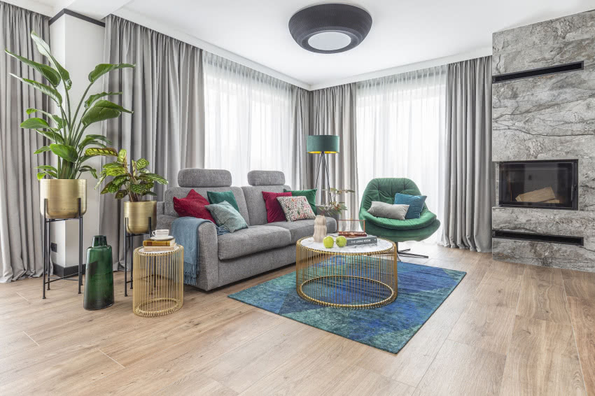 Szara wygodna sofa doskonale prezentuje się...