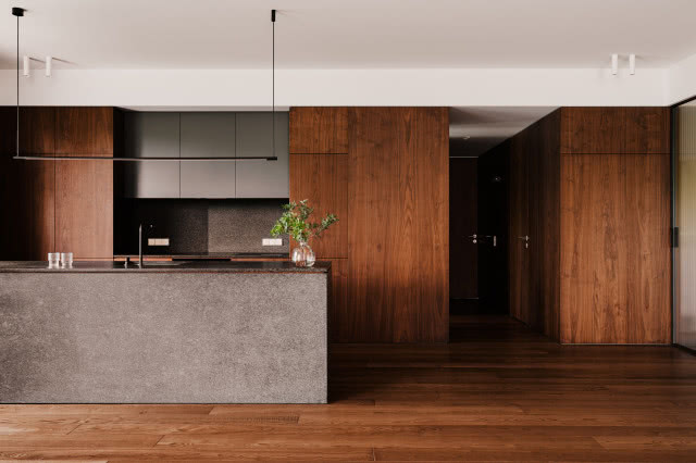 Drewniana kuchnia z nowoczesną wyspą kuchenną z kamienia