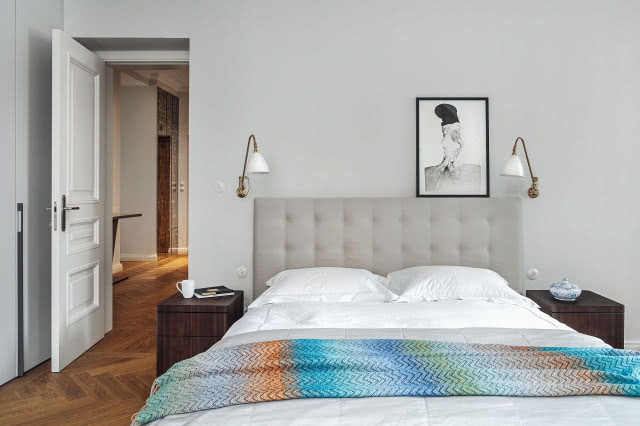 W sypialni główne miejsce zajmuje wygodne łóżko Arca. Do tego klasyka Poliformu świetnie pasują kinkiety Gubi, przydatne podczas wieczornej lektury.