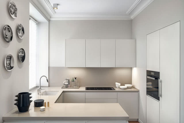 Na minimalistyczną kuchnię
"spoglądają" twarze Lina Cavalieri z kolekcji talerzy Fornasetti, którymi
udekorowano ścianę.