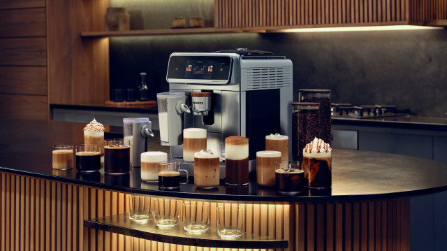 Ekspres Philips LatteGo Pro 8000 w eleganckiej kuchni, otoczony różnymi rodzajami kawy, od espresso i latte po mrożone napoje z pianką.