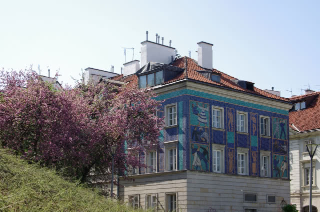 Niebieska mozaika z kwitnącym drzewem.