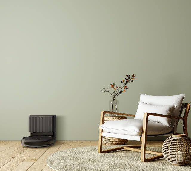 czarny iROBOT, fotel, stolik, wazon z gałązkami, dywan